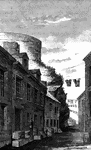 Place where Arnold was wounded. This view is in a narrow alley near the north end of <em>Sault au Matelot</em> Street, in the rear of St. Paul's Street. At the time in question St. Paul's Street did not exist, and the water, at high tide, came nearly up to the precipice. The first barrier and battery extended from the jutting rock seen in the picture, to the water. The present alley was then the beach. The circular wall on top of the rock is a part of the grand battery, one of the most formidable and commanding defenses in the world.