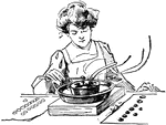 A woman using a fondue pot to make chocolate covered nuts.