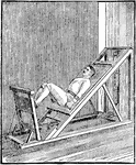 A man exercising with the short inclined plane. This device is used for leg exercises.