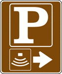 This is an example of a directional sign with a secondary symbol. It is used to indicate that amphitheater parking is located to the right.