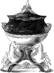 This tureen is footed with two horse figures at the base. The tureen lid has a small infant figure at the top and the handles are in a fish design.