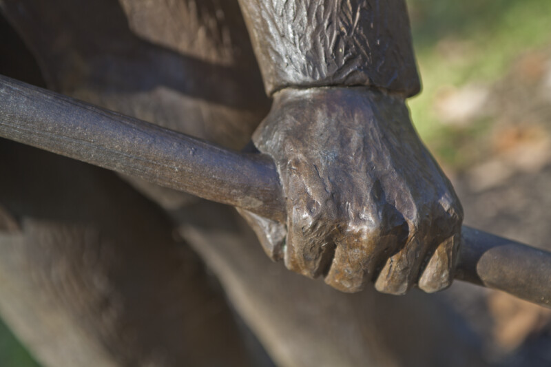 A Close-Up of the Hand of a Bronze Sculpture Depicting a Farmer