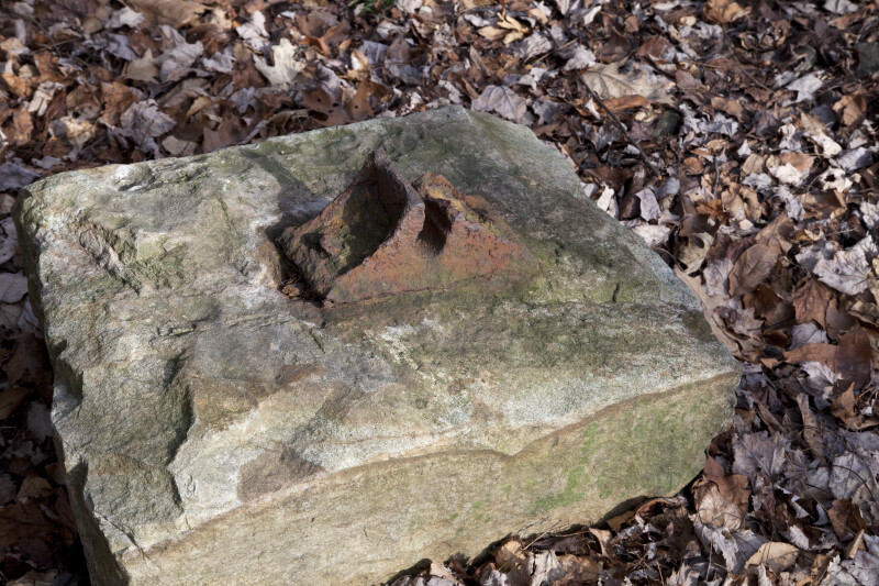 A Rusted Cast Iron Chair Attached to a Stone Sleeper