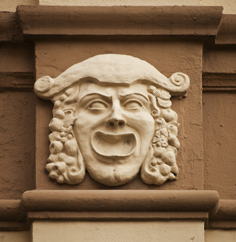 A Sculpted Face, with a Hat, on a Building