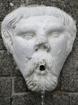 A Sculpted Face, with an Upturned Nose, on a Masonry Wall