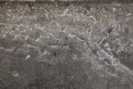 A section of concrete or stone with a filmy residue on its surface.
