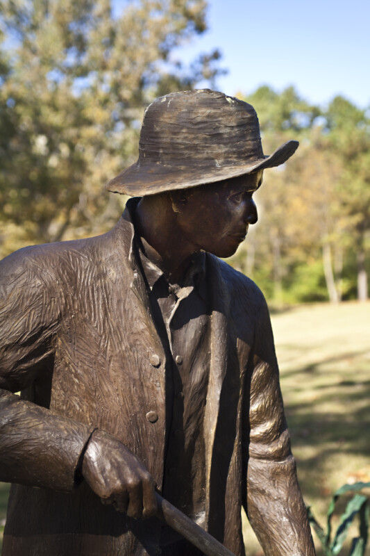 A Side View of a Bronze Sculpture Depicting a Farmer