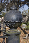 A Sphere on a Post at the Corner of a Metal Fence around a Cemetery Plot