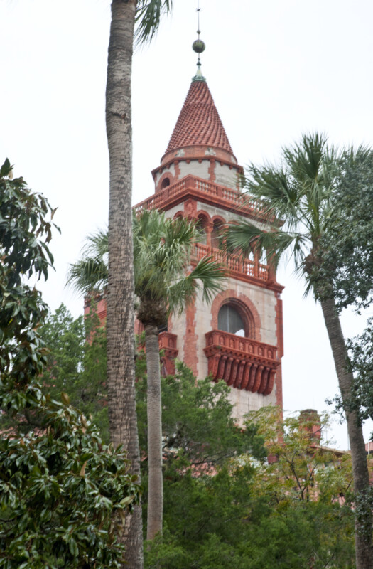 A Square Tower with a Conical Roof and Palm Trees
