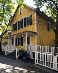 A White Fence around a Yellow House