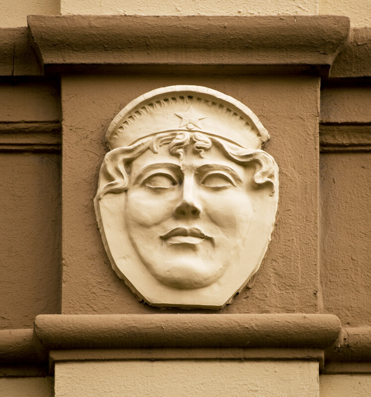 A Woman's Sculpted Face, with a French Hood, on a Building