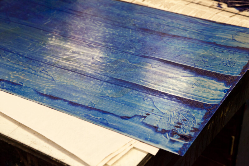 An etching plate with blue ink ready for wiping.