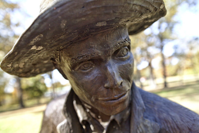 An Oblique Close-Up of the Face of a Bronze Sculpture Depicting a Farmer
