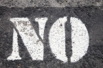 Asphalt with "NO" Written in White Paint