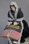 Belgium Doll Making Lace in Bruges, Belgium with Bobbins and Thread (Three Quarter Top-Down View)