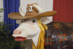 Cow Statue with Red Lipstick, Cowboy Hat, and Coat