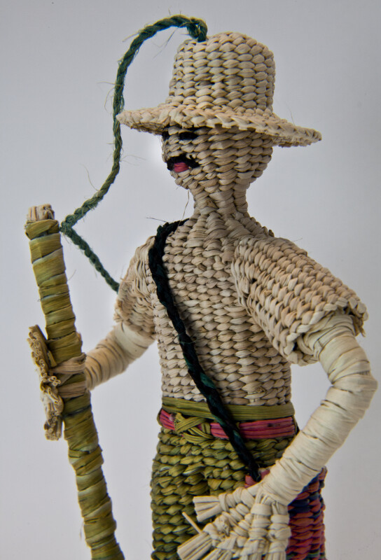 Ecuador Handcrafted Male Figure Made with Woven Straw Holding a Pole (Close Up)