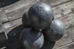 Four Cannonballs Stacked on Wooden Boards