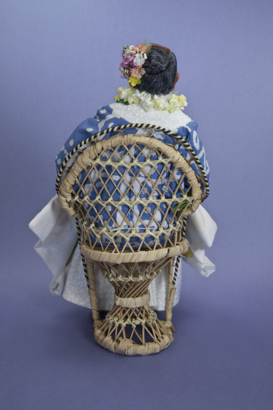 Hawaiian Handcrafted Woman with Flower Lei Sitting in Wicker Chair (Back View)
