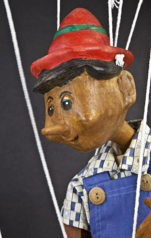 Italy Pinocchio Wooden Toy Puppet Marionette Sitting with Strings  (Close Up Three Quarter View)