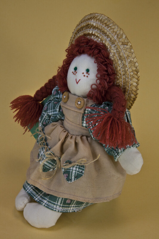 Prince Edward Island Anne of Green Gables Doll Wearing a Pinafore and Straw Hat (Three Quarter View)