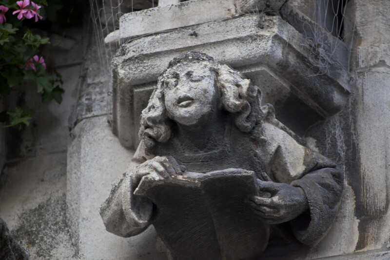 Sculpture of a Man Reading a Book on a Corbel