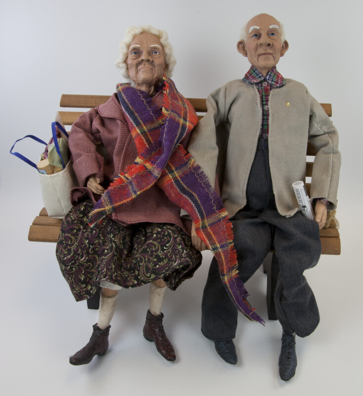 Texas Male and Female Senior Citizen Dolls by Karen Germany Sitting on a Bench (Full View)