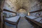 Two Wooden Beds in a Room Adjacent to the Entrance of Castillo de San Marcos