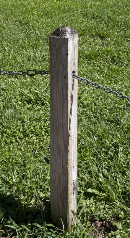 Wooden Post that has Metal Chain Running Through it